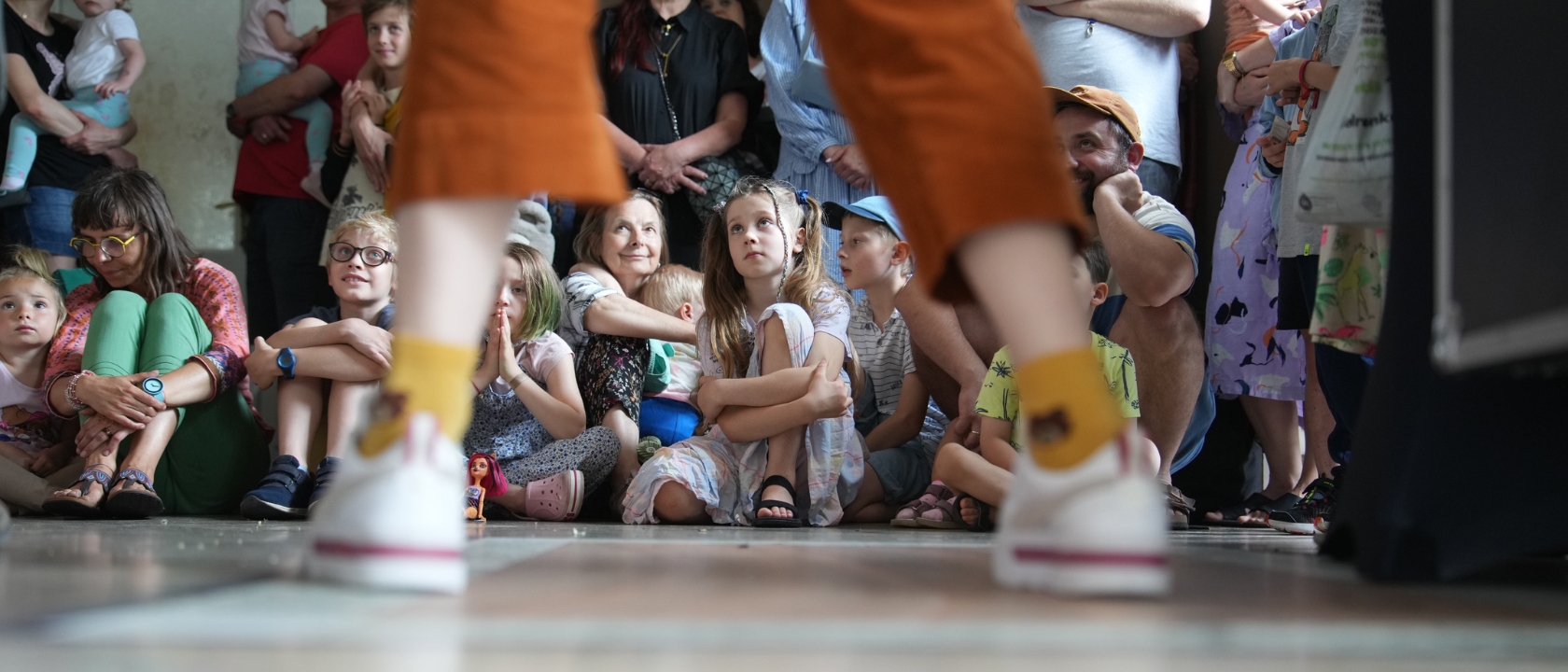 na zdjęciu nogi i kilka dzieci w tle