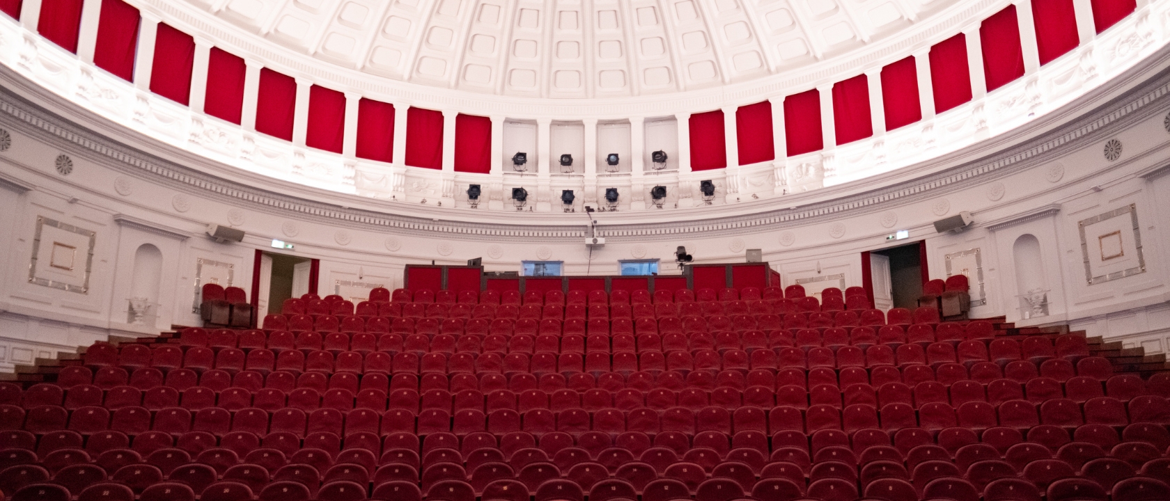 zdjęcie przedstawia widownię Teatru Komedia, widać rzędy foteli, architekturę wnętrza, kopułkę na suficie
